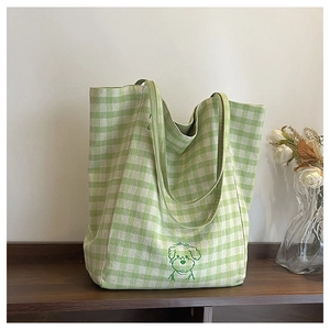 Détail du sac cabas en toile à carreaux verts et blancs avec motif de chien brodé