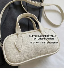 Detailed close-up of textured beige Boston bag with soft pebbled leather and sturdy handles