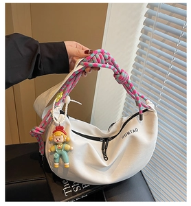 Bolso bandolera blanco en forma de media luna con asa de cuerda trenzada y colgante