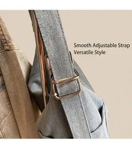 Detail of adjustable silver buckle on a light blue denim tote bag shoulder strap