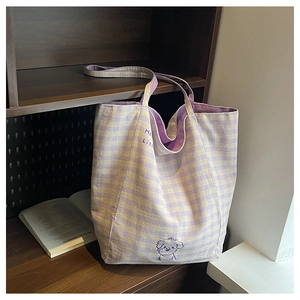 Détail du sac cabas en toile vichy avec motif de chien violet sur étagère