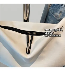 Detalle de cremallera doble con tiradores negros en un bolso de tela blanca elegante