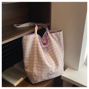 Détail du sac cabas en toile à carreaux avec broderie de chien violet et texture douce
