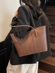 Sac fourre-tout en cuir marron avec surpiqûres dans un décor intérieur élégant