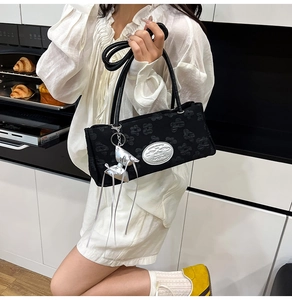 Borsa a spalla in nylon nero testurizzato con ciondolo a fiocco argento e rilievo floreale