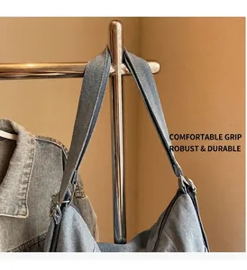 Close-up of blue denim tote bag featuring adjustable metal buckle and wide shoulder strap