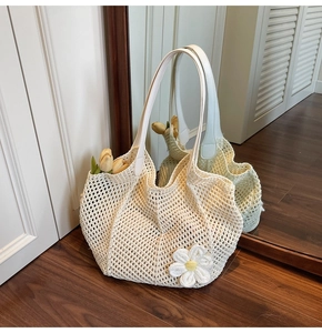 Detailed macro view of cream crochet tote bag featuring 3D flower and white leather handles