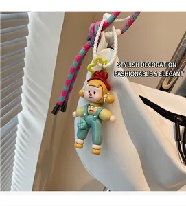 Detalle de un colgante de niña de dibujos con hebilla de estrella en un bolso blanco