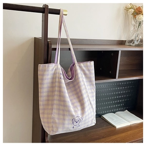 Détail du cabas en toile à carreaux violets avec imprimé chien dans un décor chaleureux