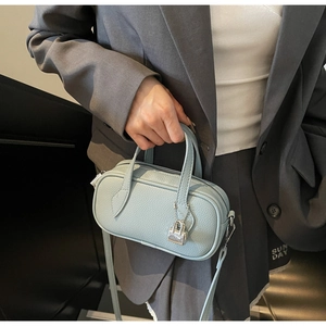 Detail of light blue lychee pattern leather Boston bag with silver metal lock charm