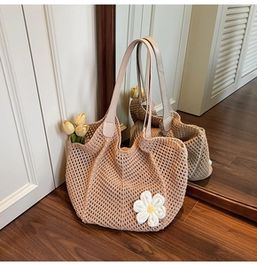Detail of hand-woven crochet tote bag with a 3D daisy flower and leather handles