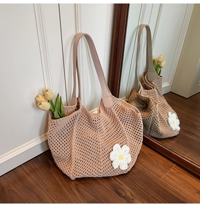 Detail of bohemian crochet tote with hollow mesh pattern and floral daisy applique