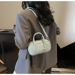 Detailed macro view of the light blue leather boston bag with a silver padlock charm accessory