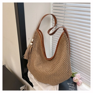 Detail der gewebten Stroh-Tasche mit Lederriemen, Quasten und Holzperlen-Dekor