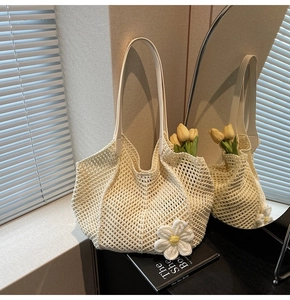 Detail of hand-woven cream crochet tote bag with large flower and white shoulder straps