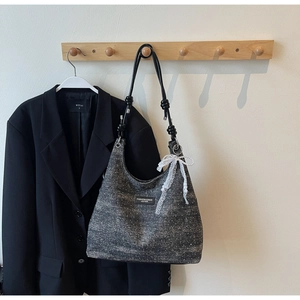 Détail du sac bandoulière en tweed moucheté avec nœud en dentelle blanche et perle décorative