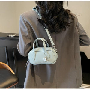 Detail showing mint blue leather mini pillow bag with silver lock and double handles