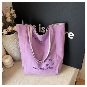 Détail d'un sac cabas en toile violette avec texte stay soft but protect your boundaries