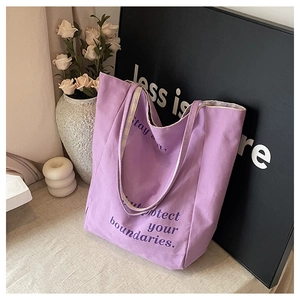 Détail d'un sac cabas en toile lilas avec slogan artistique et décor moderne épuré