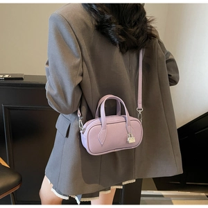 Detail of light purple pebbled leather Boston bag with silver lock and double handles