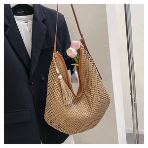 Detailaufnahme einer gewebten Hobo-Tasche mit Lederbesatz und Quasten-Anhängern