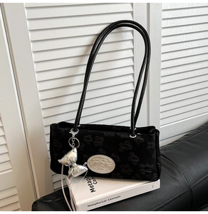 Dettaglio della borsa sottobraccio in nylon jacquard nero con ciondolo a farfalla