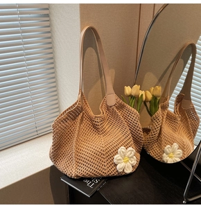 Detail of crochet straw tote bag with floral accent and faux leather shoulder strap