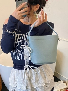 Light blue bucket bag with leather texture and pearl lace bow pendant accessory