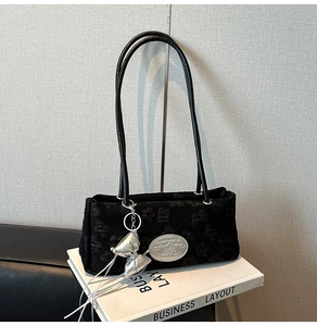Dettaglio della borsa a spalla in nylon nero con ciondolo a fiocco argento e jacquard