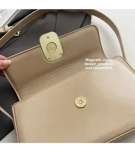Detalle del cierre magnético dorado en un bolso de hombro minimalista de cuero beige