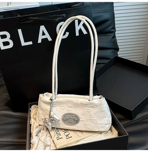Dettaglio borsa in nylon bianco con ciondolo a fiocco argento in scatola regalo