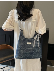 Sac bandoulière en denim bleu foncé avec poignée argentée et nœud en dentelle