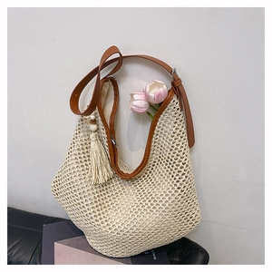 Detail der beige handgewebten Schultertasche mit braunem Lederbesatz und Quasten