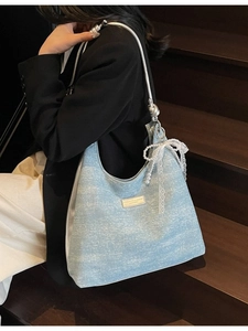 Sac sous le bras bleu clair à chaîne avec nœud en dentelle et perles sur un mannequin
