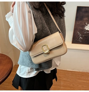 Detalle del bolso de hombro beige con hebilla dorada elegante y cuero sintético de calidad