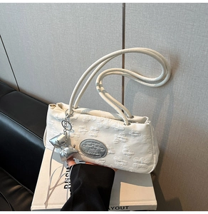 Dettaglio della borsa a spalla in nylon bianco con ricamo floreale 3D e ciondolo