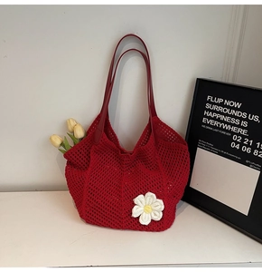 Detail of red crochet tote bag with white daisy flower and leather shoulder straps