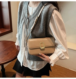 Detalle del bolso beige de cuero sintético con hebilla dorada y correa ajustable