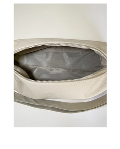 Detail of herringbone fabric lining and smooth zipper inside the beige nylon pillow bag