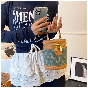Detailansicht der Denim-Beuteltasche mit Lederbesatz und goldenem Logo-Reißverschluss
