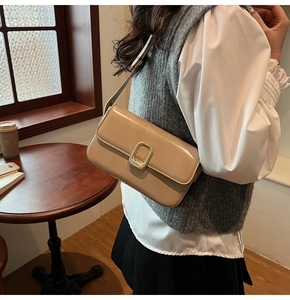 Detalle de bolso beige minimalista con hebilla dorada y textura de cuero de alta calidad