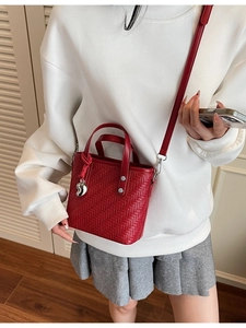 Borsa a secchiello intrecciata rossa alla moda con ciondolo a cuore e tracolla regolabile