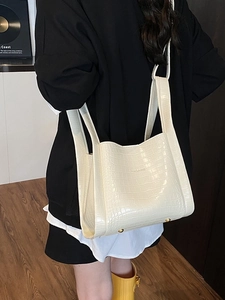 Minimalist cream white crocodile embossed tote bag with wide shoulder straps shown in use