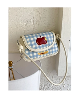 Detail of blue plaid square bag featuring an apple patch and Not Anxious text