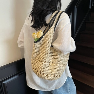 Detailed texture of straw tote bag with black piping and hollow weave design
