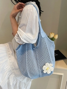 Light blue woven tote bag with white daisy detail and leather handles for summer beach use