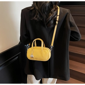Detailed back view of a yellow mini boston bag showing fine litchi grain leather and strap