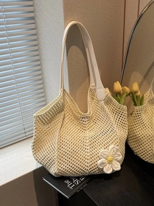 Fashionable woven beach tote bag with leather straps and knit daisy flower decoration