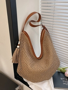 Gewebte Stroh-Tasche mit braunen Lederriemen und Quasten-Detail für Strandurlaube