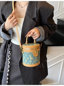Blaue Denim-Jacquard-Beuteltasche mit Lederbesatz, getragen von einem Model